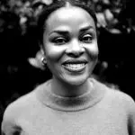Black-and-white portrait of a smiling woman.