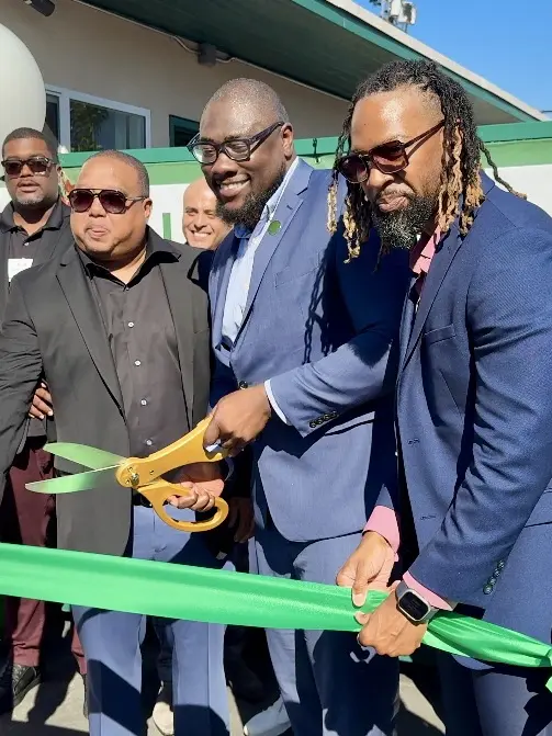 Community partners and leaders cutting a green ribbon at the La Ramona Family Housing celebration.