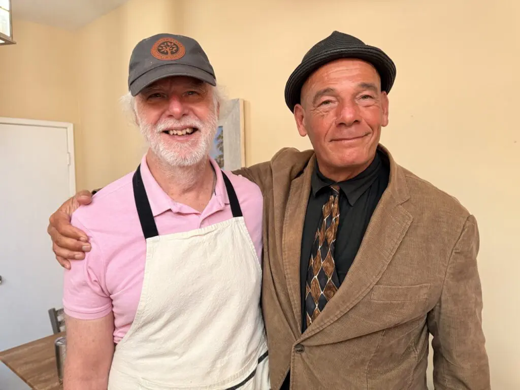 Kevin McArdle shares a warm embrace with another person at St. Joseph Center's Bread & Roses Café.