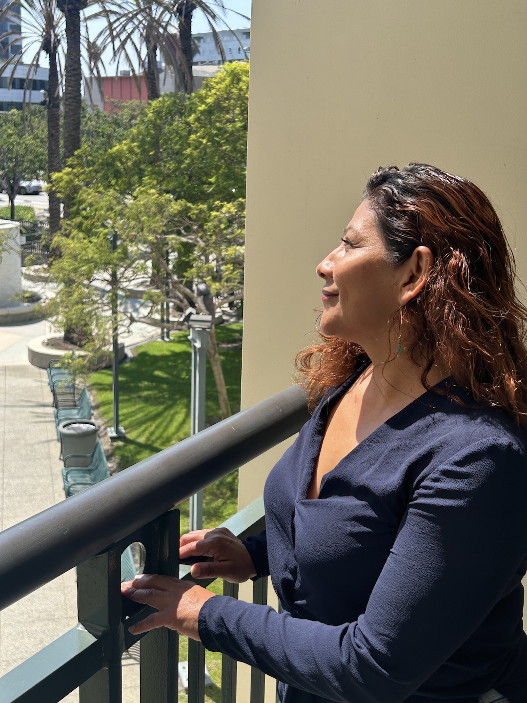 Elizabeth Rodriguez smiling outdoors in an editorial-style portrait.