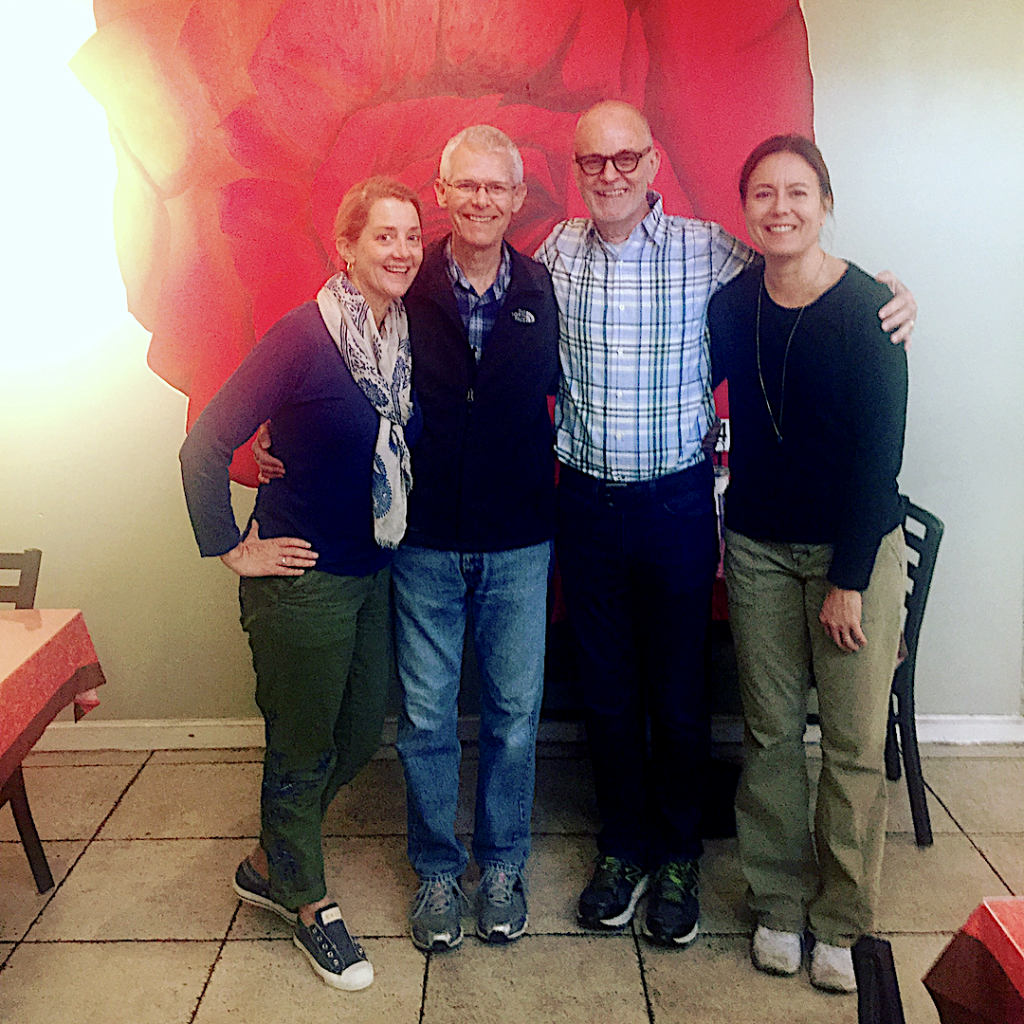 Jocelyn Cortese standing with fellow community members inside Bread &amp; Roses Café, smiling together.