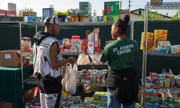 Two St. Joseph Center volunteers working at a food pantry.