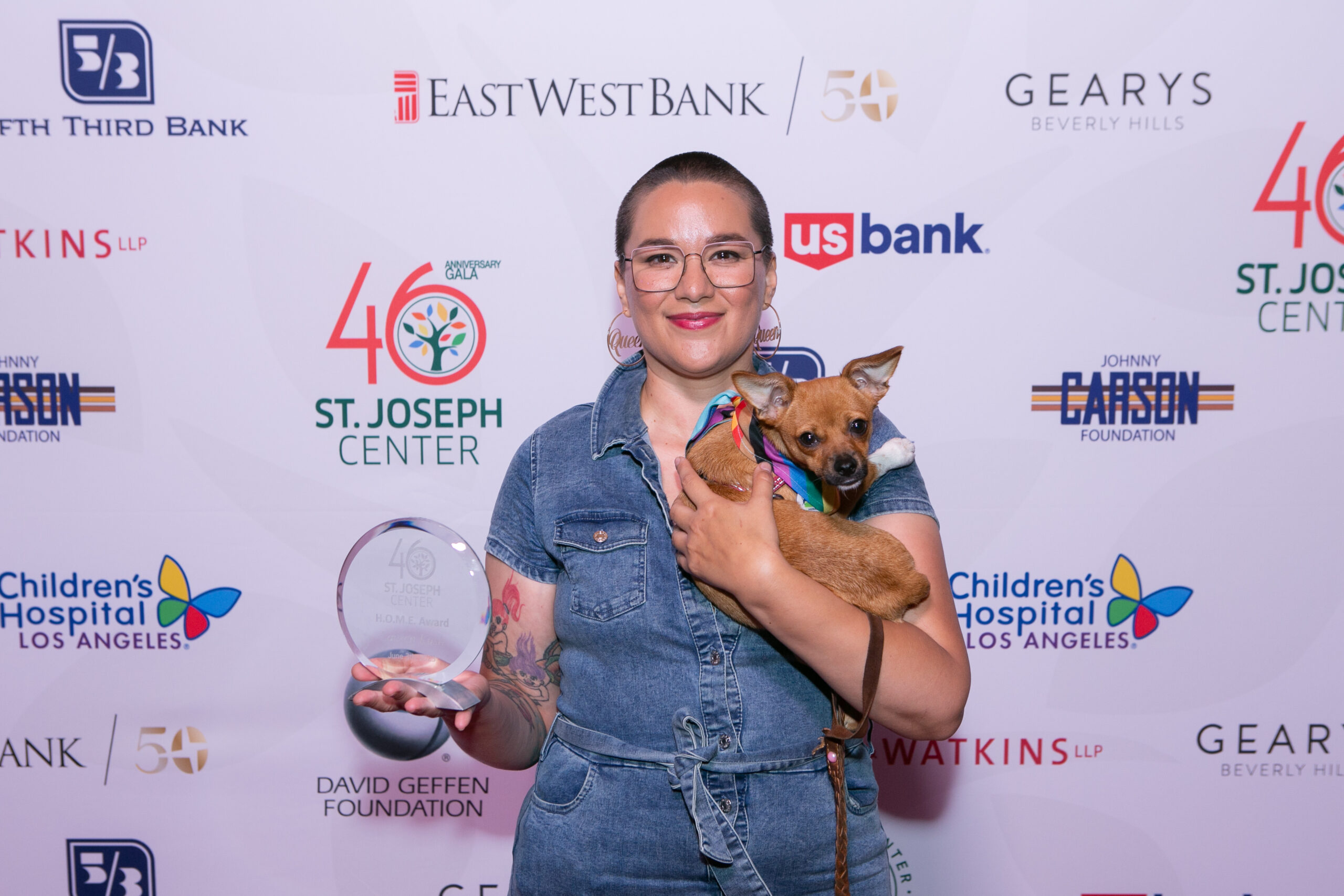 Lauren Kush holding the H.O.M.E. Award at St. Joseph Center’s 46th Anniversary Gala with her dog.