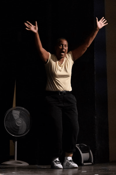 Renee Westbrook performing on stage with her arms raised.