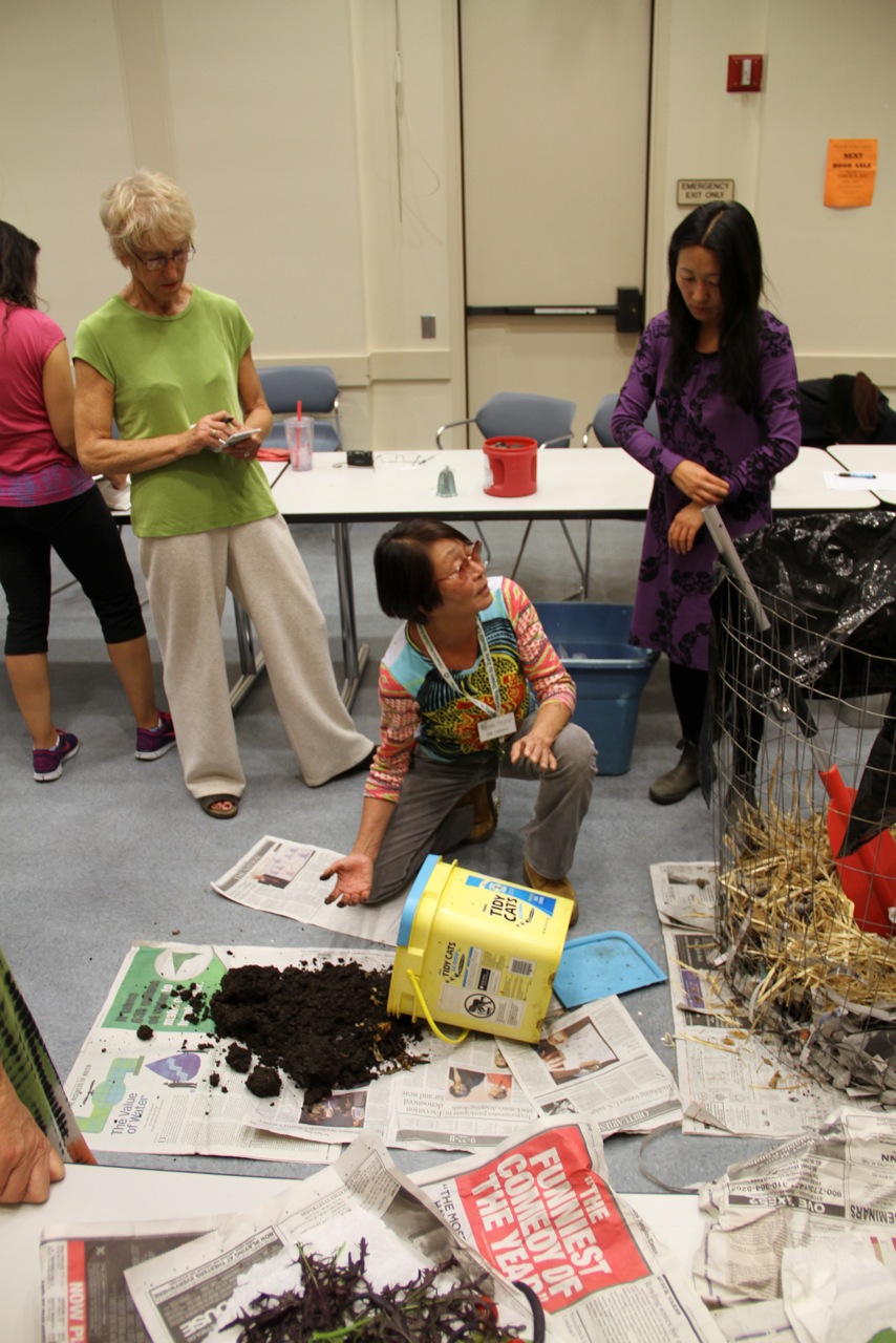 Emi Carvell leading a hands-on gardening workshop, teaching sustainable practices to community members