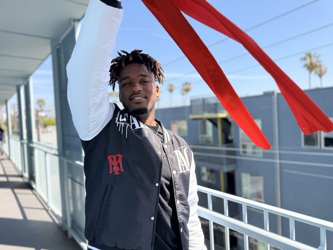 Malik Jackson holding a ceremonial ribbon during a celebration