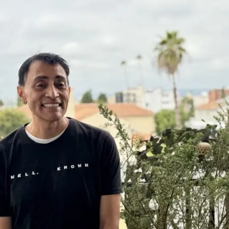 Daniel, smiling outdoors on a patio.