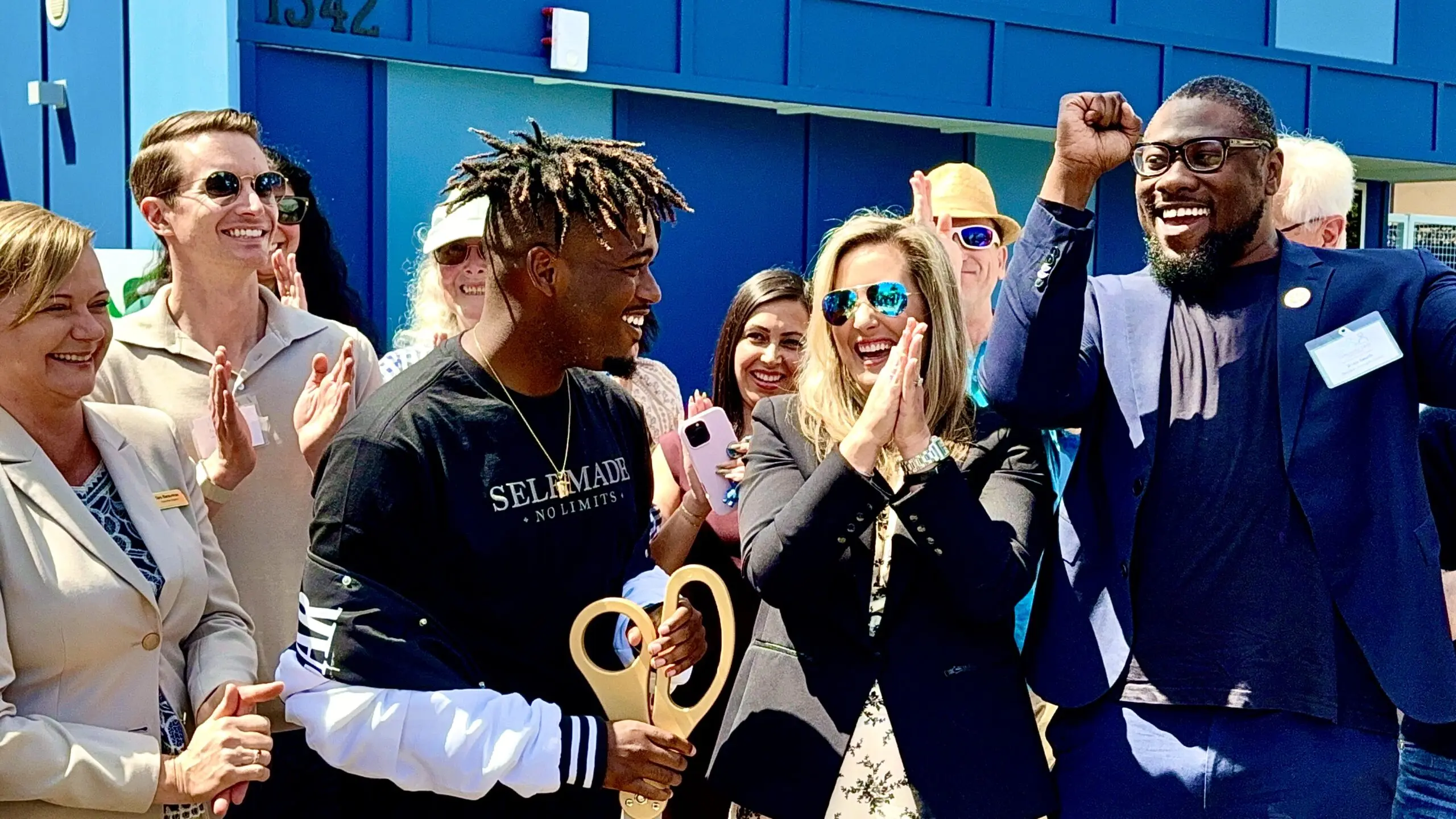Malik Jackson holding a ceremonial ribbon during a celebration