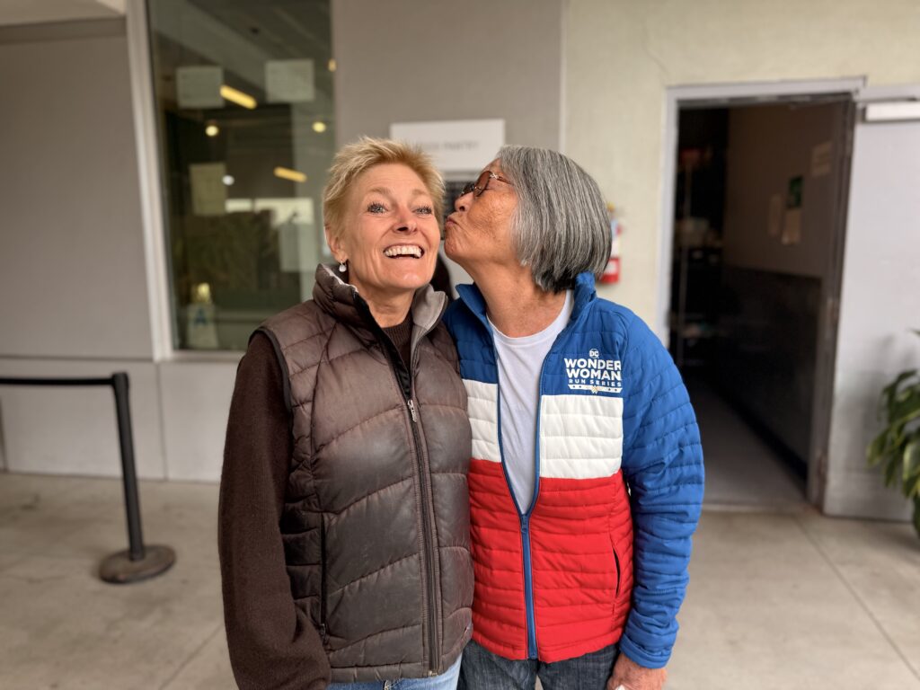 Emi Carvell shares a joyful moment with a fellow volunteer at St. Joseph Center.