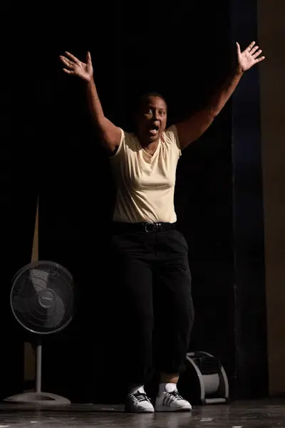 Renee Westbrook performing on stage with her arms raised.