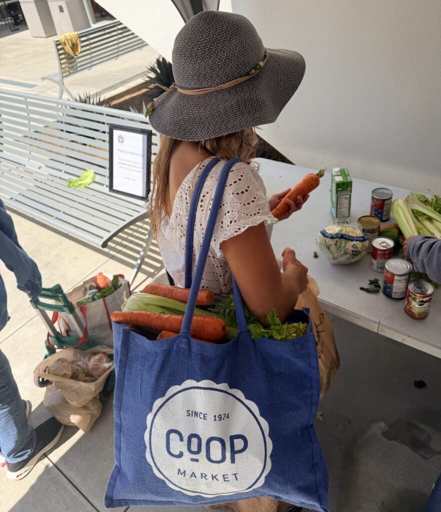 Food Pantry visitor selects fresh produce at St. Joseph Center’s Bread &amp; Roses Food Pantry in Venice.