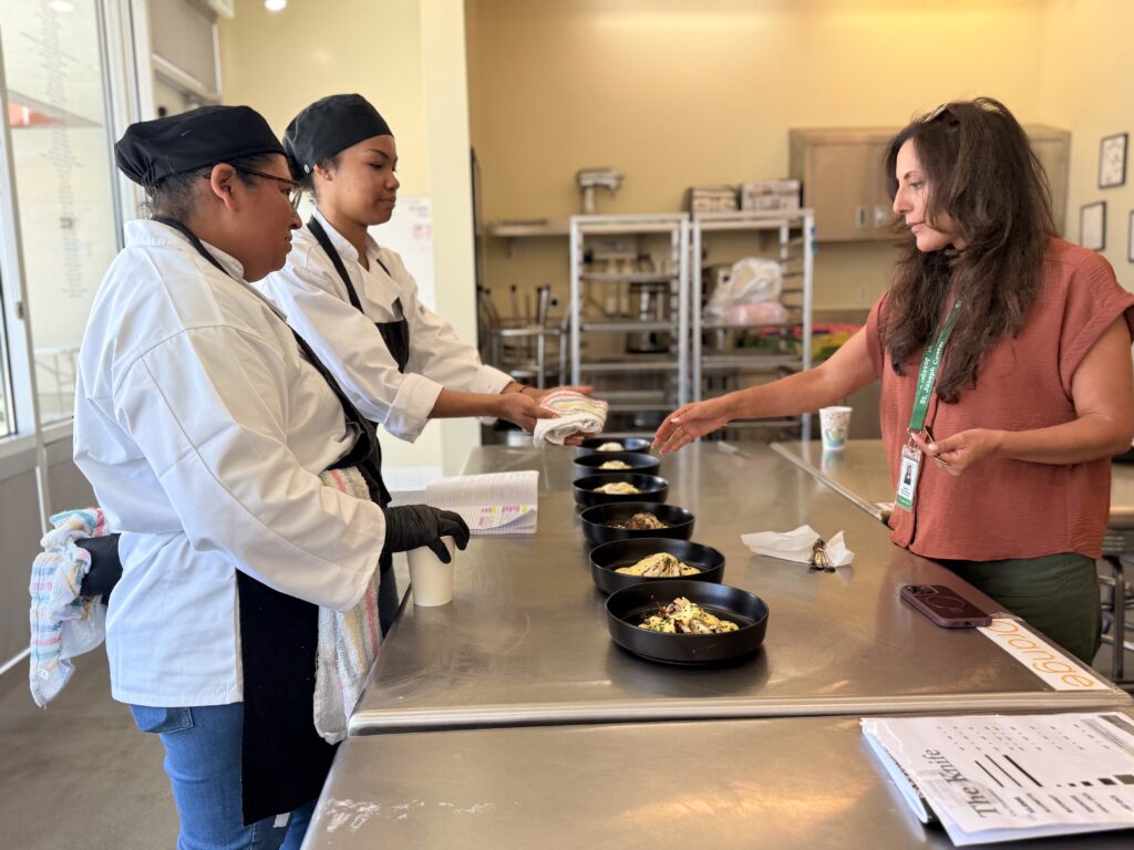 Culinary students preparing food together in St. Joseph Center’s Bread & Roses Training Kitchen.